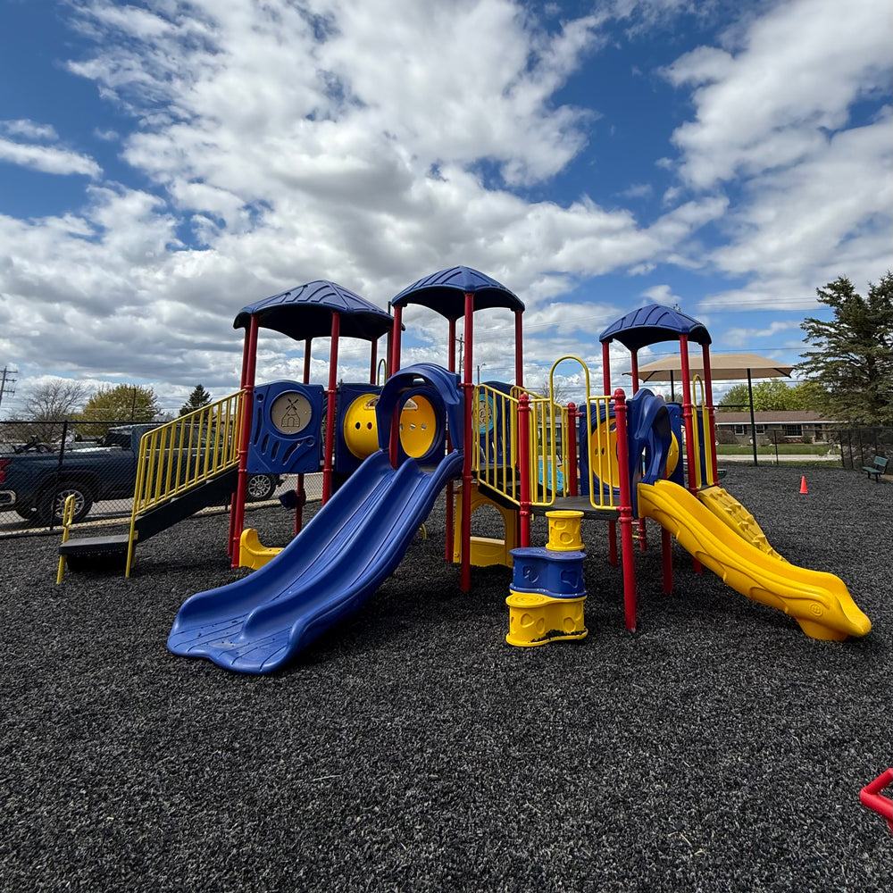 A commercial modular play structure installed on rubber surfacing